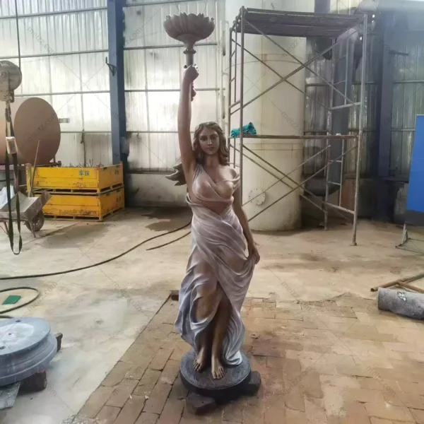 lady holding lamp statue