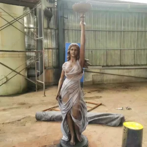 lady holding lamp statue