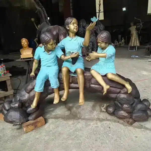 three children on log statue red outfit