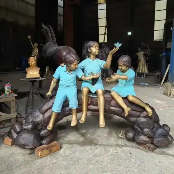 three children on log statue red outfit