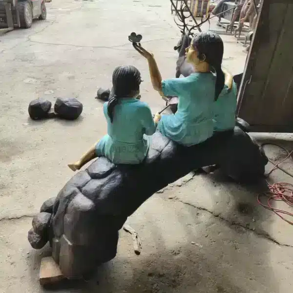 three children on log statue red outfit