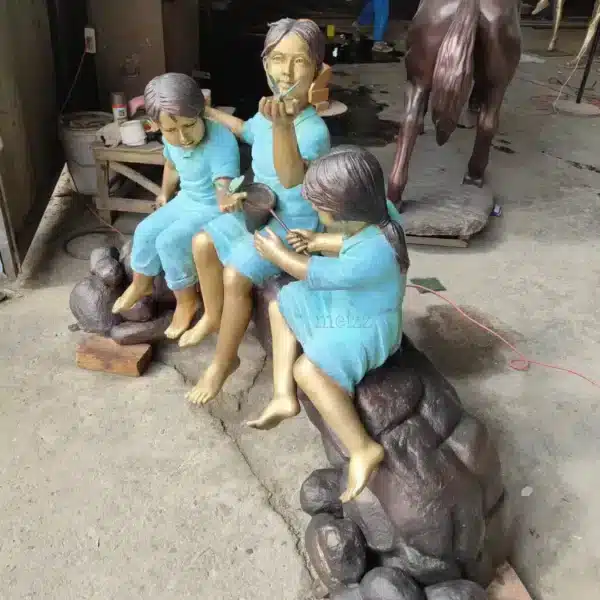 three children on log statue red outfit